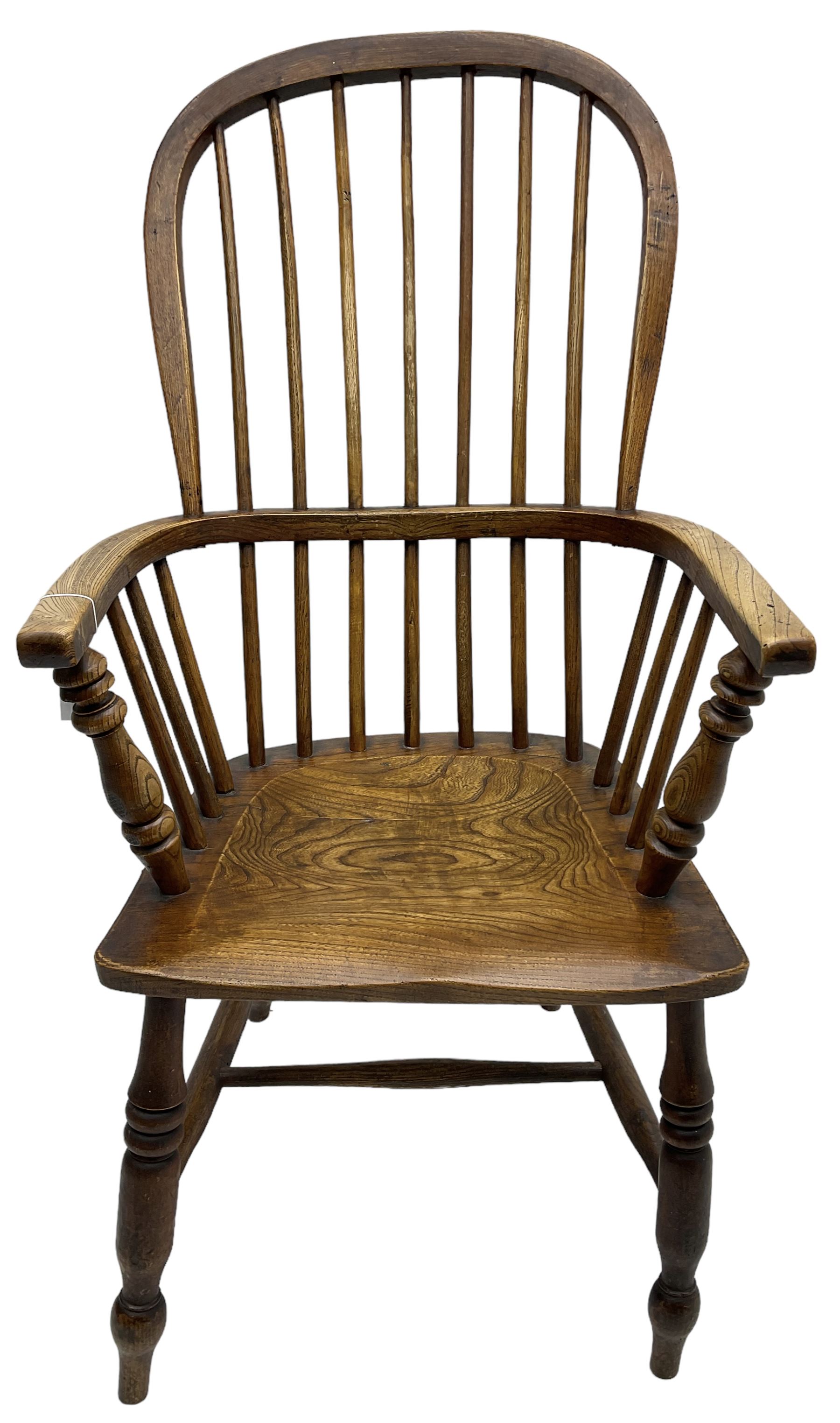 Early 19th century elm Windsor chair, high hoop and stick back over shaped saddle seat, raised on ring turned supports united by H-stretcher