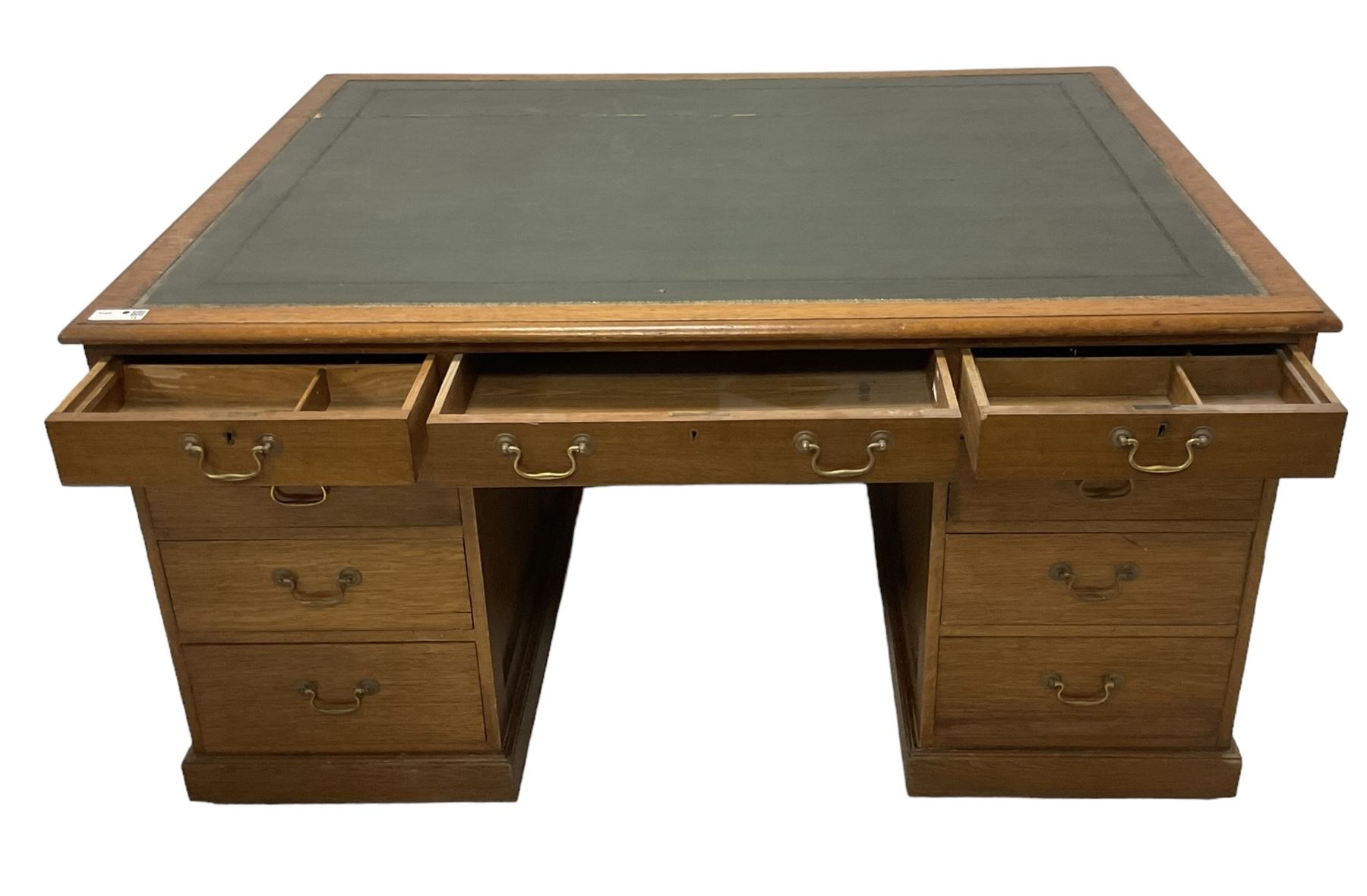 Late 19th century twin pedestal oak partner's desk, rectangular top with inset green leather writing surface, fitted with nine graduating drawers to each side, the rear drawers enclosed by panelled cupboards