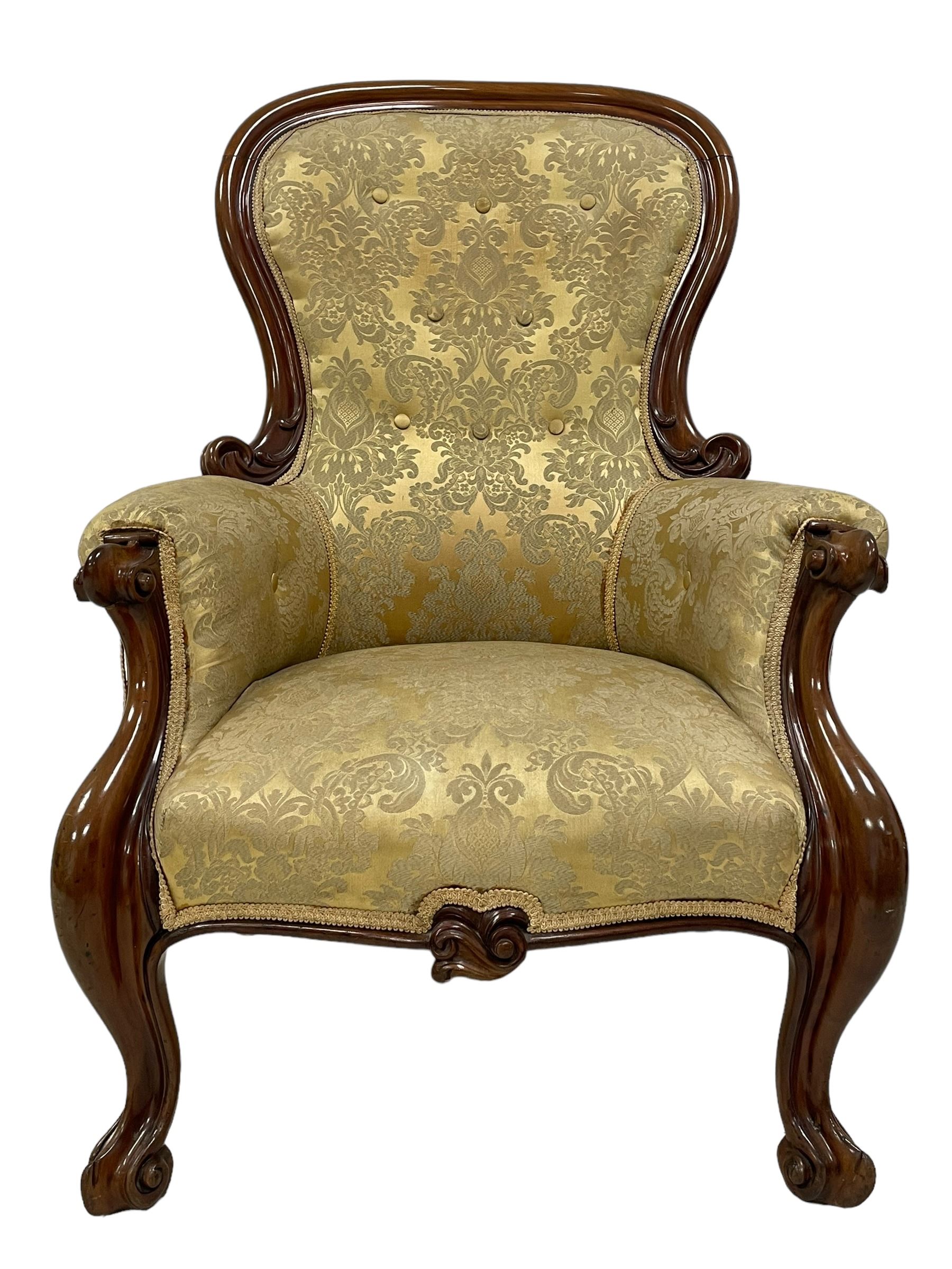 Victorian mahogany framed armchair, shaped and moulded frame carved with curled foliage, upholstered in pale gold floral pattern silk damask fabric, scrolled arm terminals on shaped moulded supports terminating to scroll carved feet