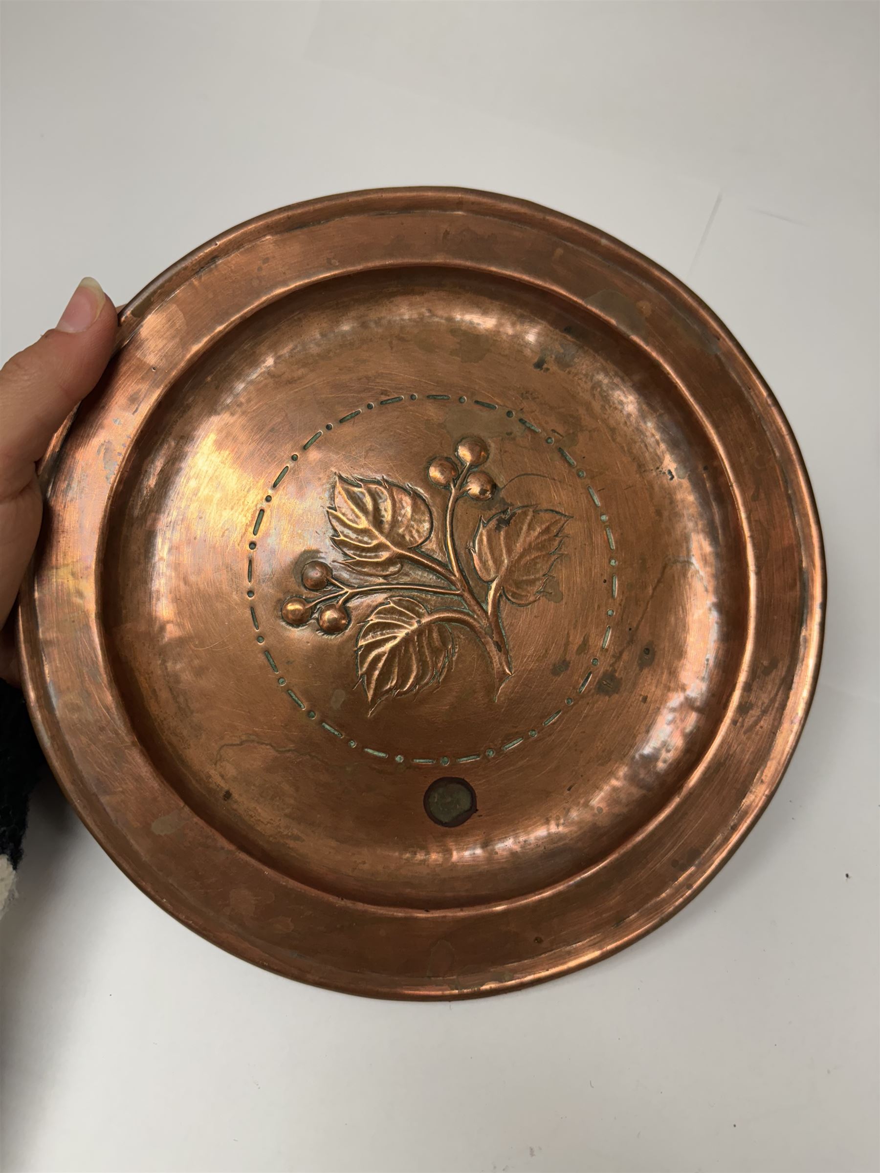 Middle eastern copper bucket, with chased and embossed band of animal decoration, together with a copper jardinière embossed with floral panels, copper plate with embossed leaf motif and two brass helmet shaped coal scuttles, bucket H26cm