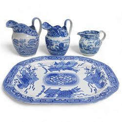 Three 19th century blue and white transfer printed jugs, two of helmet form, the other with basket weave moulded base, together with a 19th century blue and white meat plate, L52.5cm (4)