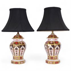 Pair of 20th century Royal Crown Derby 1128 Imari pattern table lamps, each of octagonal baluster form, with black fabric shades, each with printed mark beneath and date cods for 1996 and 1998, base H23cm, including shade H43cm