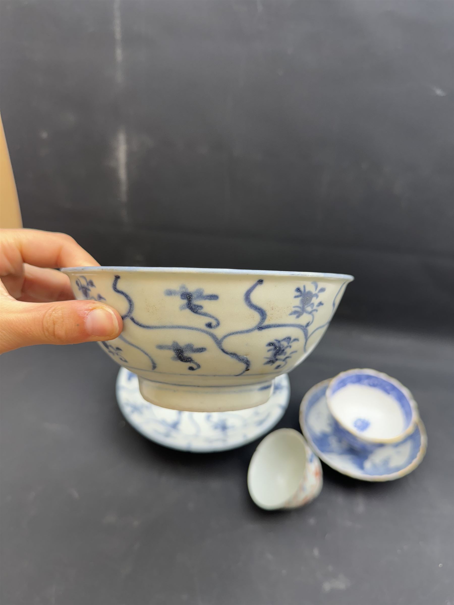 Early 19th century Chinese Tek Sing bowl, decorated with stylised blossoms, with 'Nagel Auctions' label to base, H6.5cm D15.5cm, together with a  Tek Sing similar saucer, D18cm, a Chinese tea bowl decorated in blue and red blossoming flowers, a Chinese blue and white saucer, and an English blue and white Willow pattern tea bowl, (5)