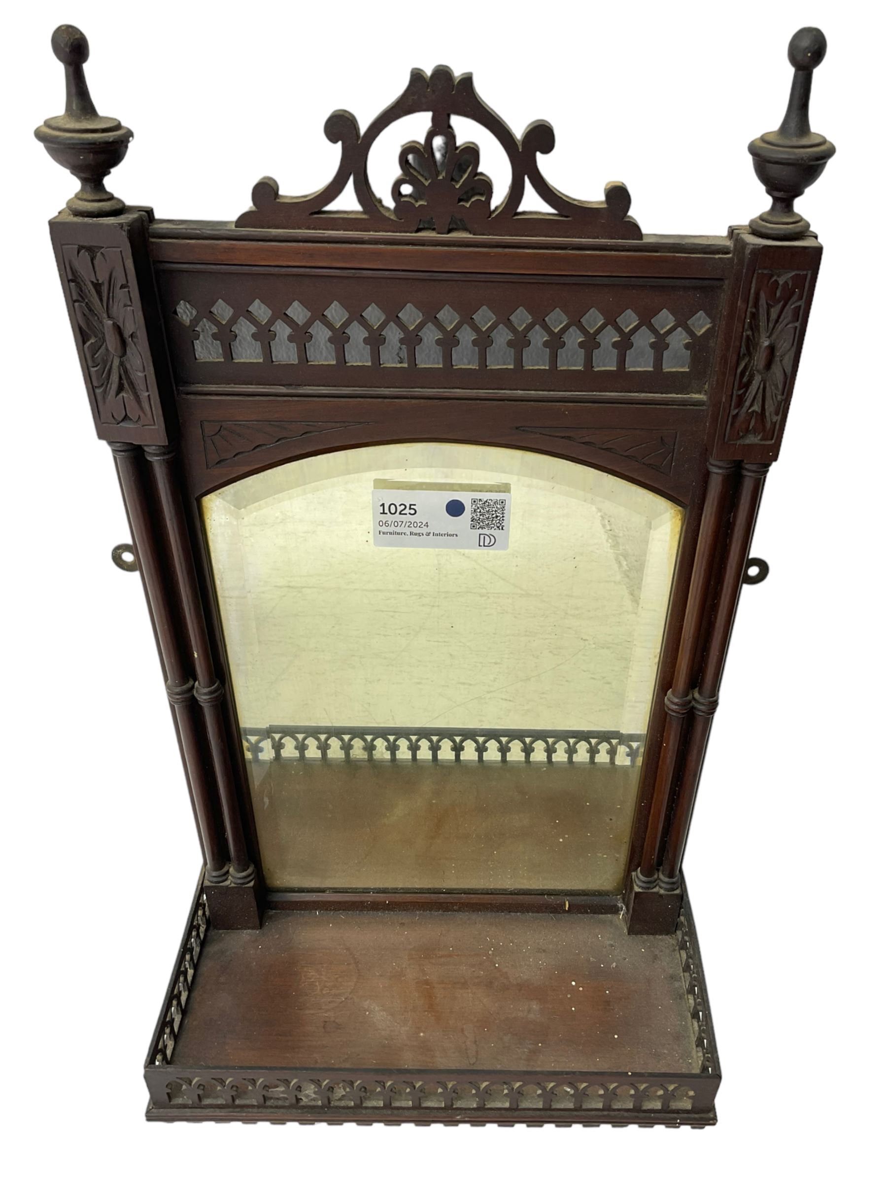 Early 20th century mahogany hall mirror with shelf, pierced pediment flanked by turned finials, the bevelled mirror plate enclosed by turned upright pillars, the shelf with fret work gallery, pierced lattice work lower panel 