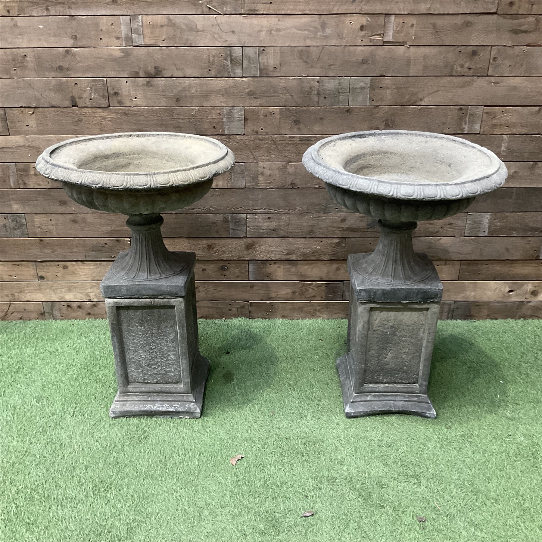 Pair of Victorian design cast stone squat garden urns, egg and dart border, raised on pedestal base and square fielded plinth - THIS LOT IS TO BE COLLECTED BY APPOINTMENT FROM DUGGLEBY STORAGE, GREAT HILL, EASTFIELD, SCARBOROUGH, YO11 3TX