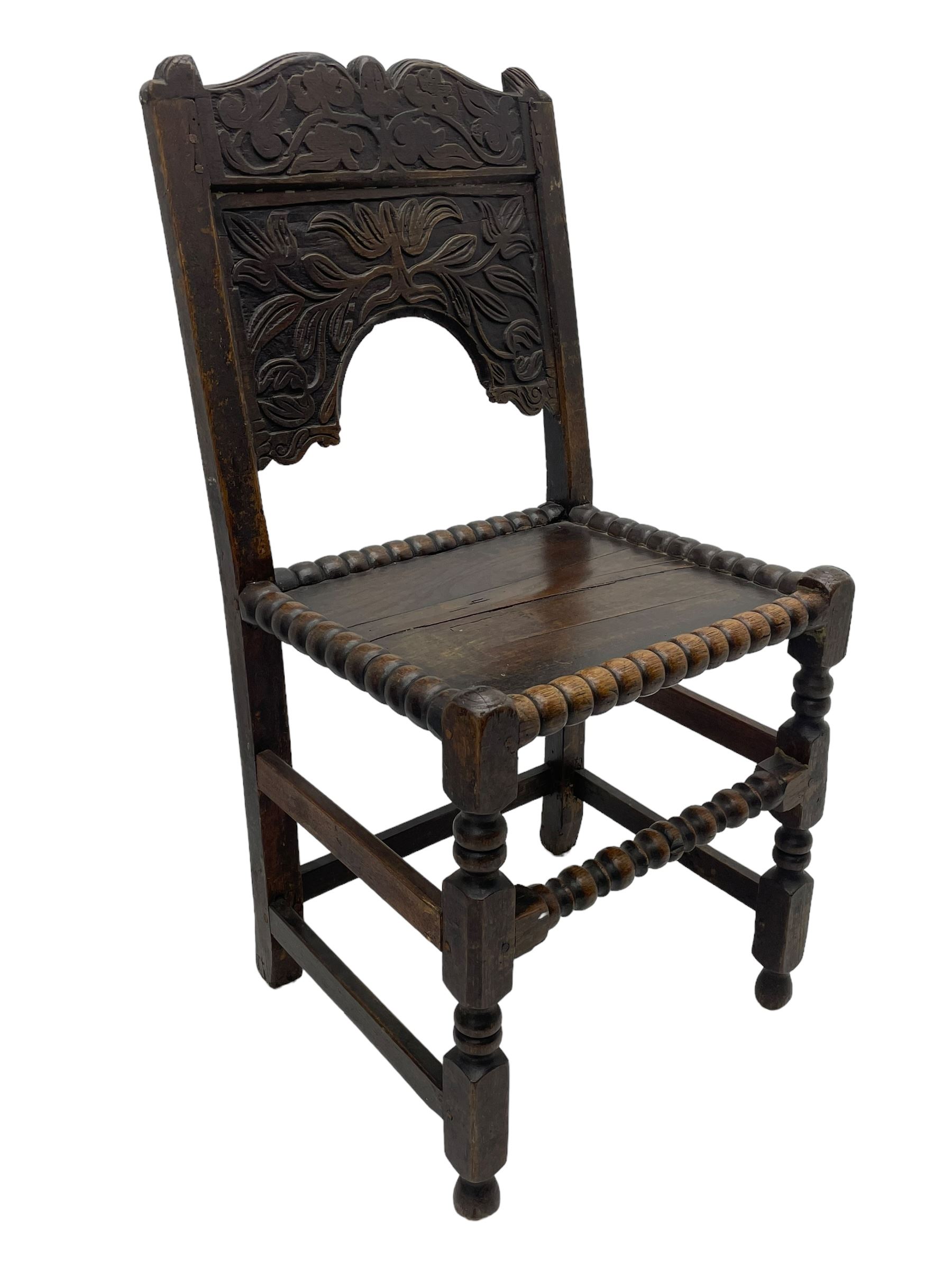 Set of three 18th century carved oak back stools, the cresting rail carved with scrolling foliate motifs over an arched panel with a stylised tree carving with extending leafage, the panelled seat held within a bobbin-turned frame, raised on turned supports united by a ring-turned front stretcher