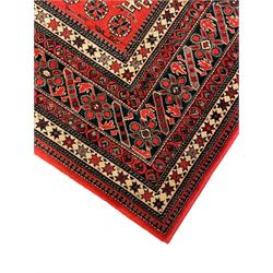 Persian design red ground rug, the field decorated with geometric motifs, repeating multiple band border 