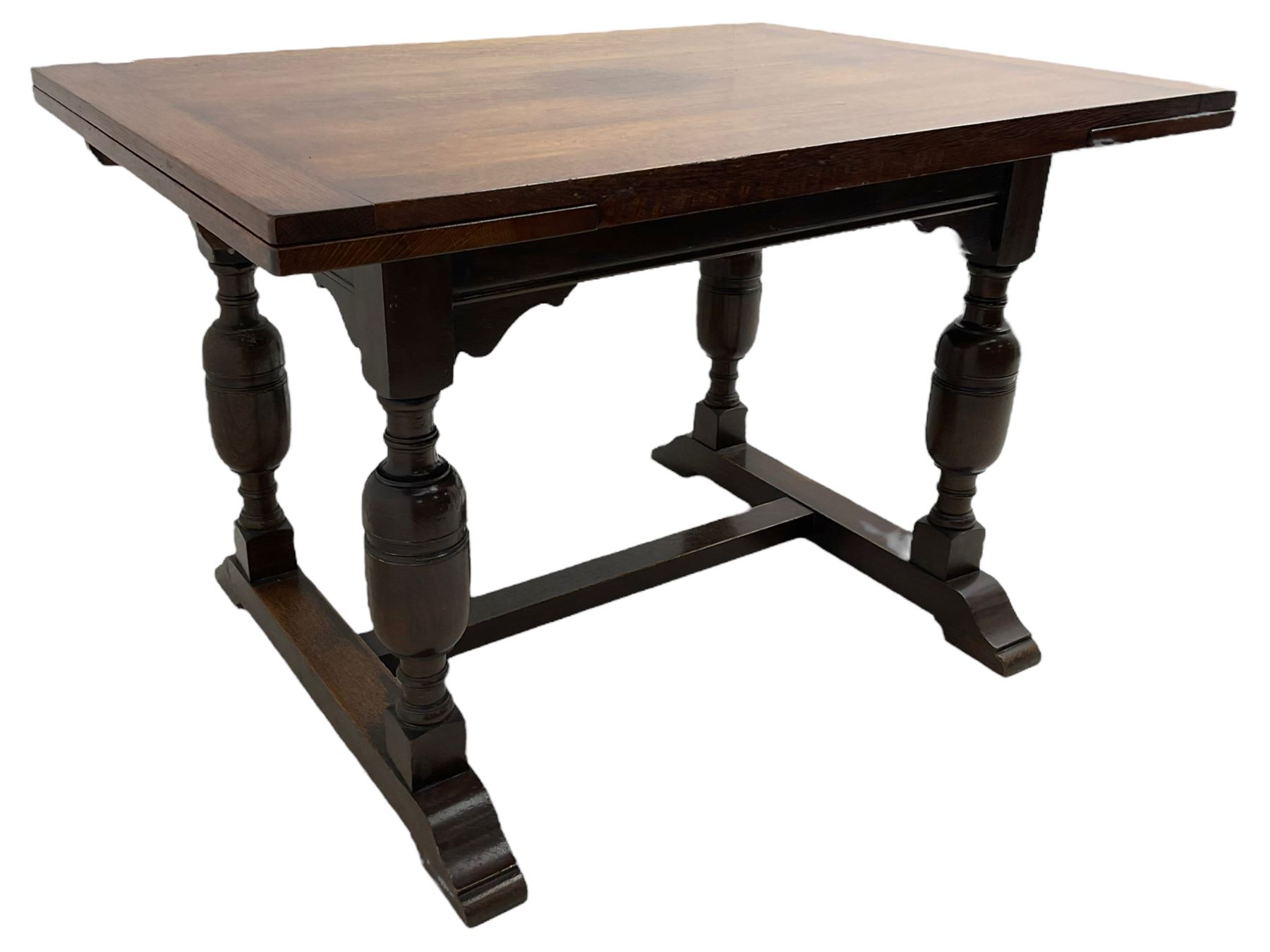 Mid-20th century medium oak dining table, rectangular draw-leaf extending top, quadruple turned pillar supports on sledge feet joined by stretcher