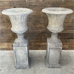 Pair of large Georgian design cast stone garden urns, egg and dart border, tapering column on square base, raised on square column