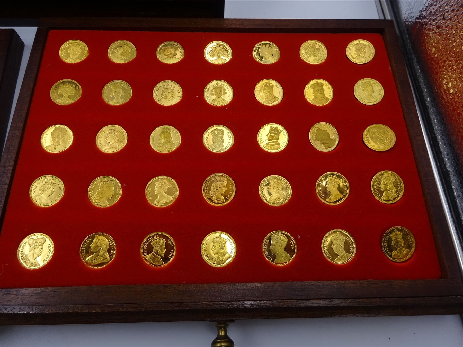 Danbury Mint, Our Royal Sovereigns Collection, seventy 22 carat gold plated silver medallions depicting the complete line of British monarchs to mark the 1200th anniversary of the first coronation, contained within wooden table top collectors cabinet with two drawers, with certificate of authenticity, with two drawers, hallmarked Danbury Mint, London various dates