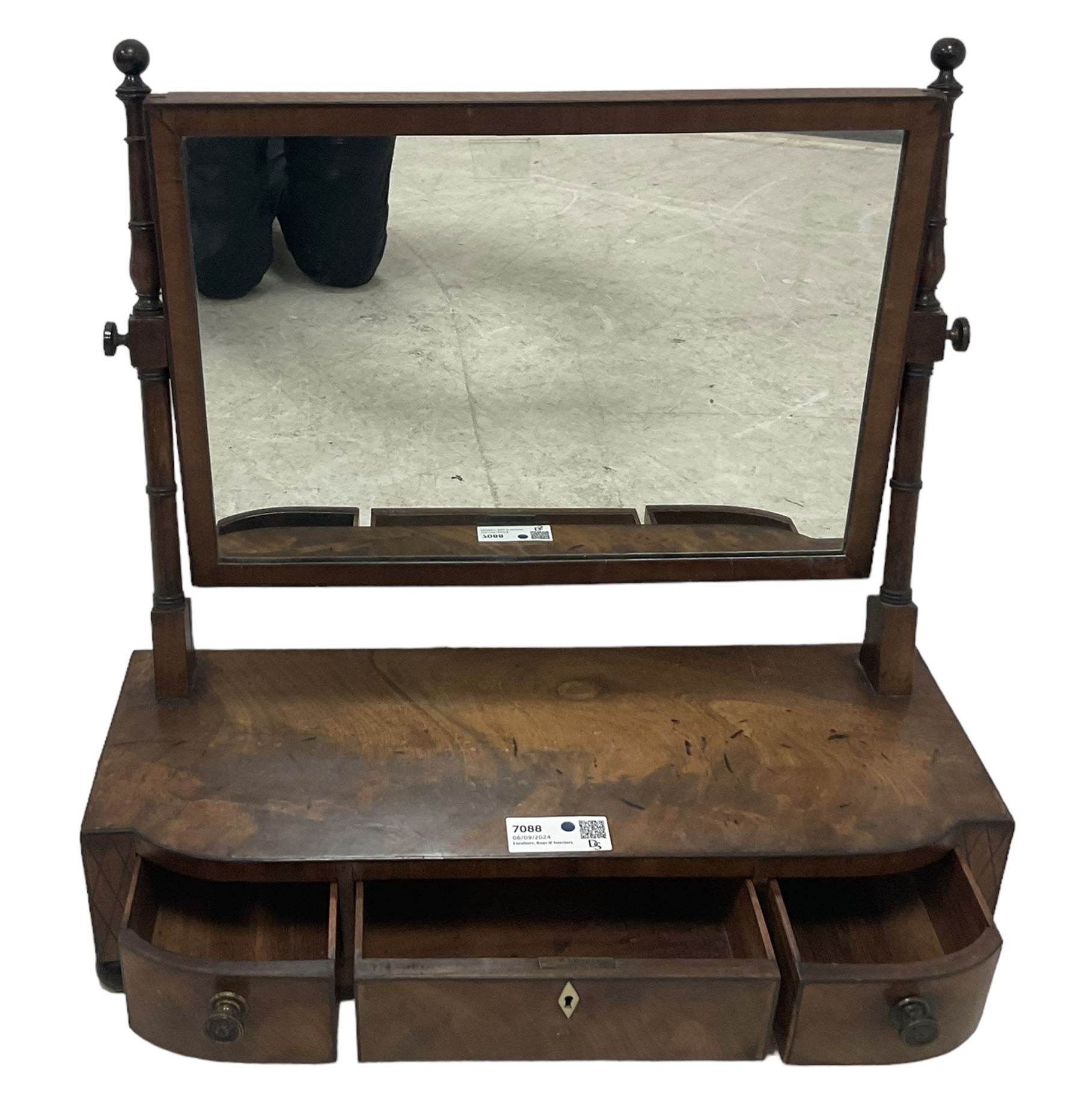 George III mahogany toilet mirror, rectangular plate on ring turned supports with swing action, three drawers with simulated ivory escutcheon, on ebonised bun feet