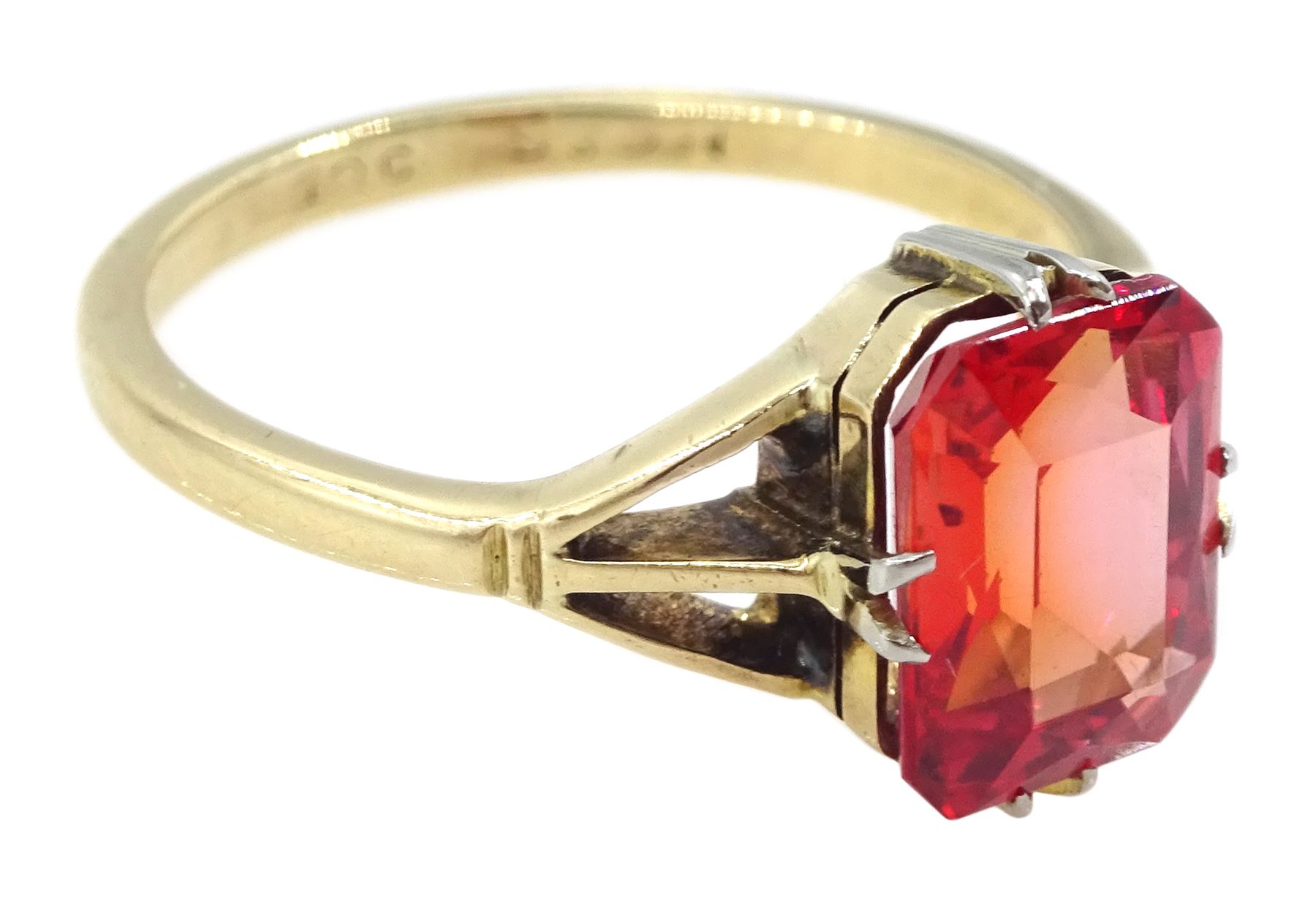 9ct gold single stone emerald cut red-orange sapphire ring, with forked shoulders