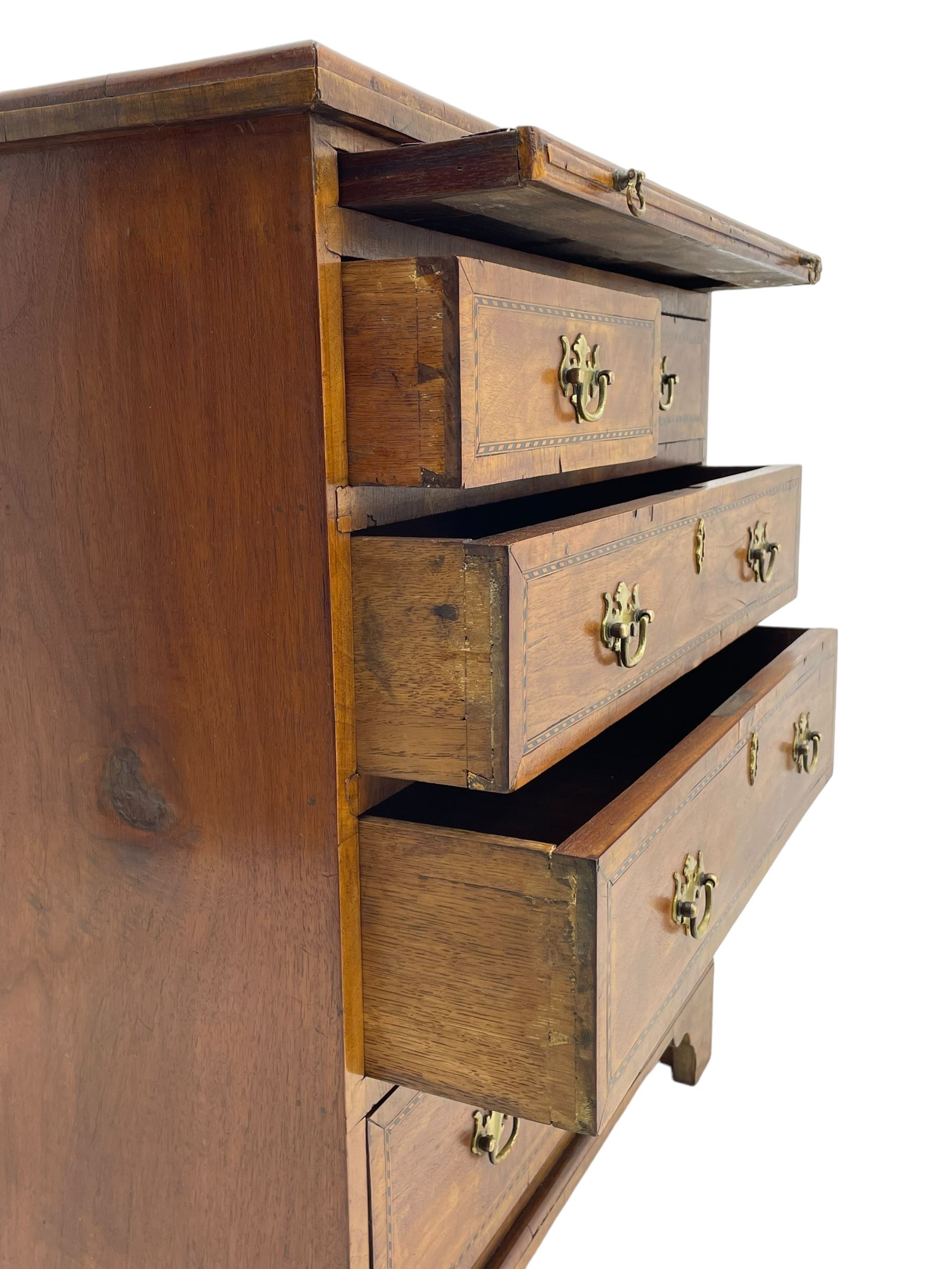 Small Georgian design walnut chest, moulded rectangular top with book-matched veneer enclosed by checkered stringing and crossbanding, brushing slide over two short and three long drawer, on bracket feet