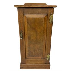 Edwardian oak bedside cabinet, raised back over moulded top, enclosed by panelled door, the interior fitted with shelves, on chamfered plinth base 