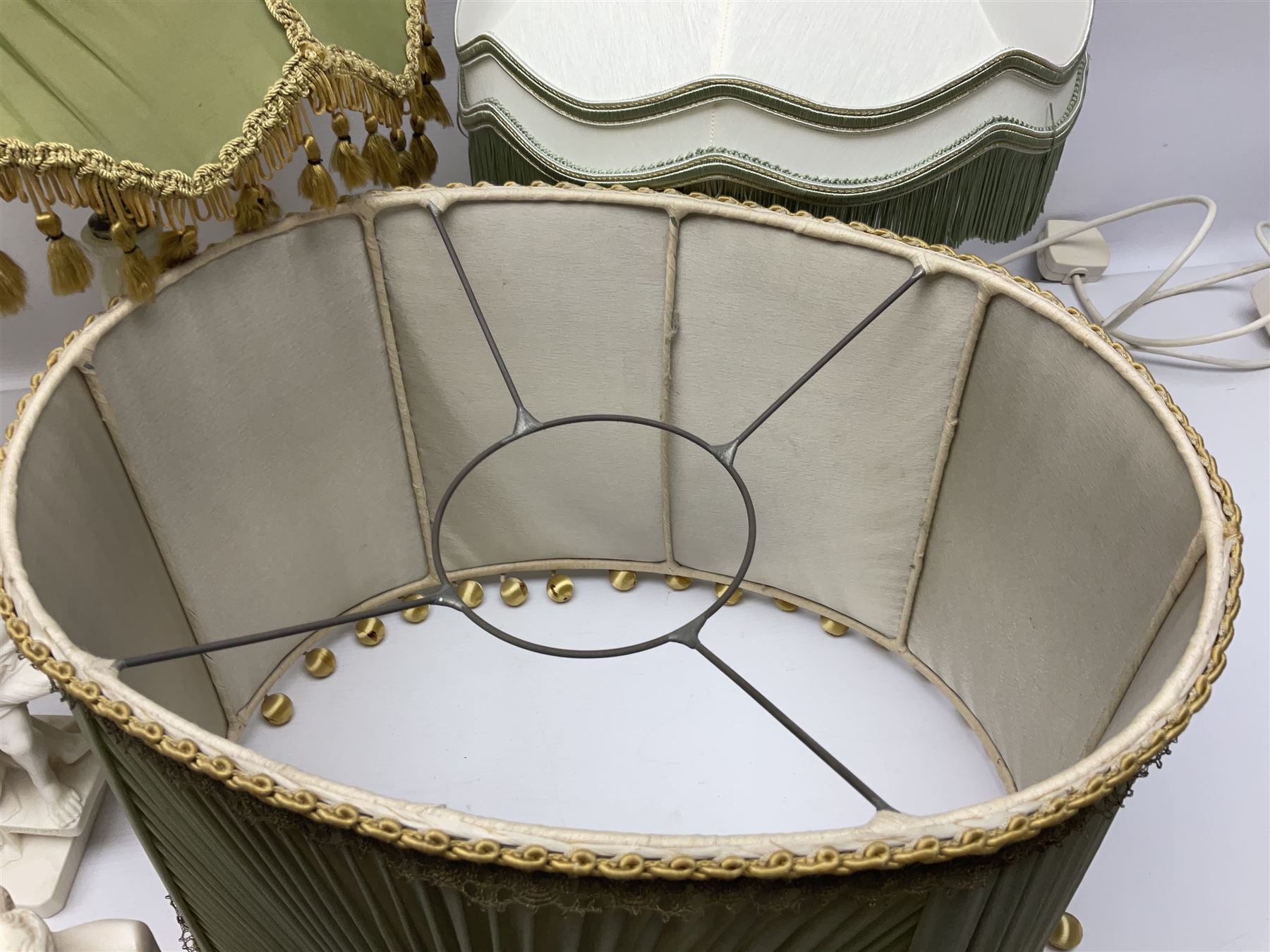 Onyx table lamp, with knopped stem and cream and green tassel shade, together with three smaller similar onyx lamps, classical style alabaster figures and a covered onyx jar