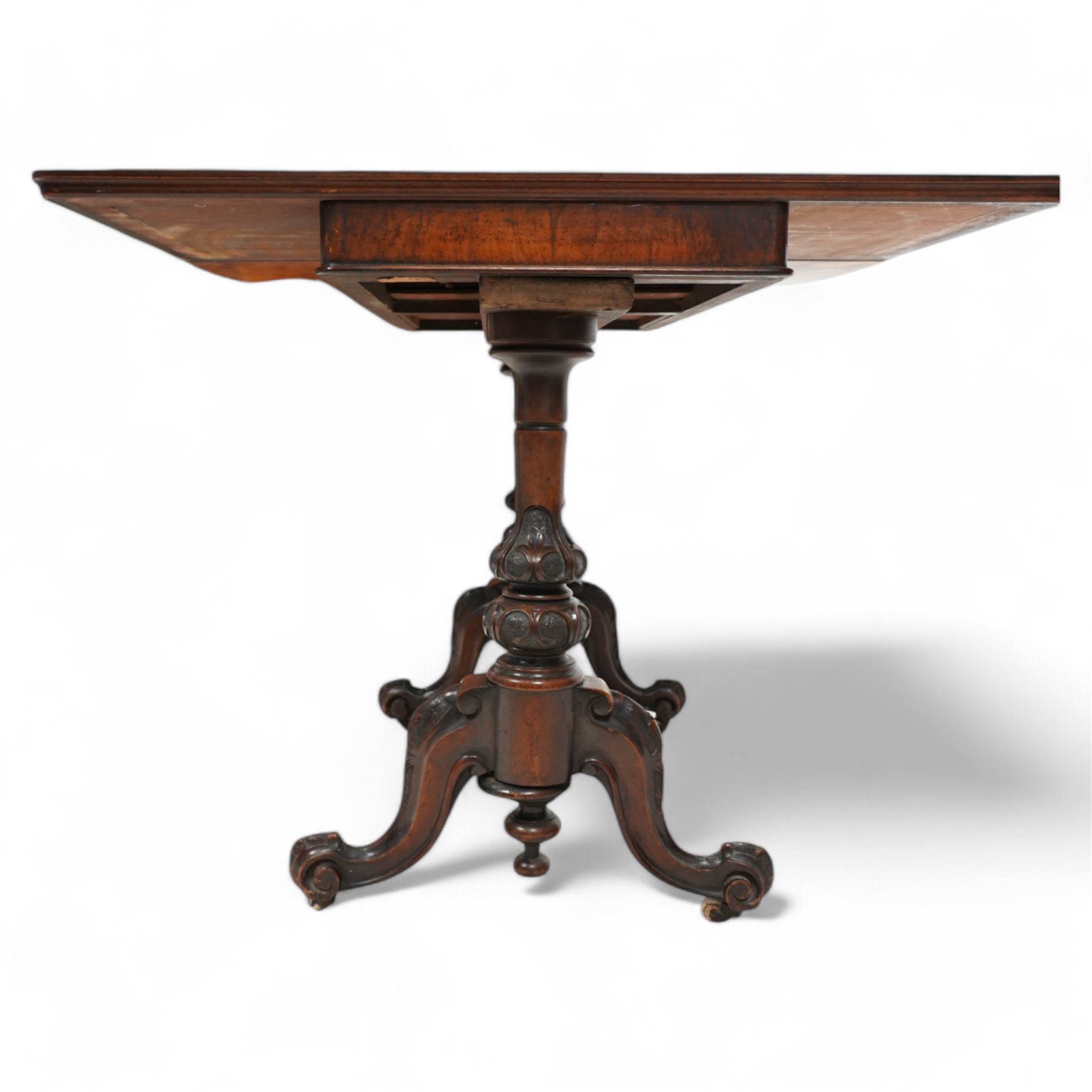 Victorian figured walnut card table, moulded rectangular fold-over swivel top with baize-lined interior, on twin turned pillar supports carved with stylised foliate motifs, united by turned stretcher, on splayed shaped feet with scrolled carved terminals, brass and ceramic castors 