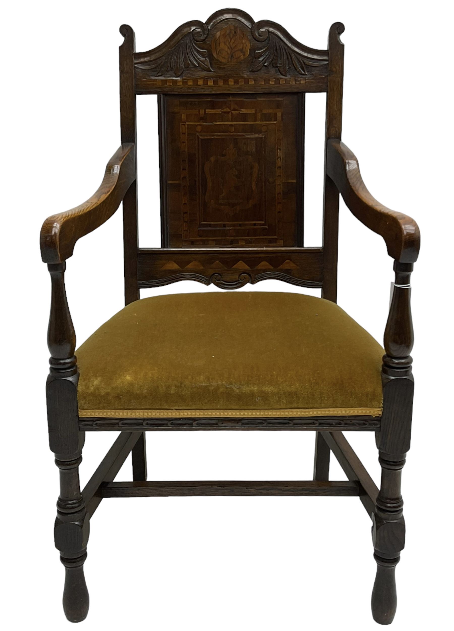 Late 19th to early 20th century oak elbow chair, the shaped cresting rail carved with scrolls and foliage, panelled back inlaid with parquetry work and central rampant lion within shield, upholstered seat, on turned supports joined by H stretchers