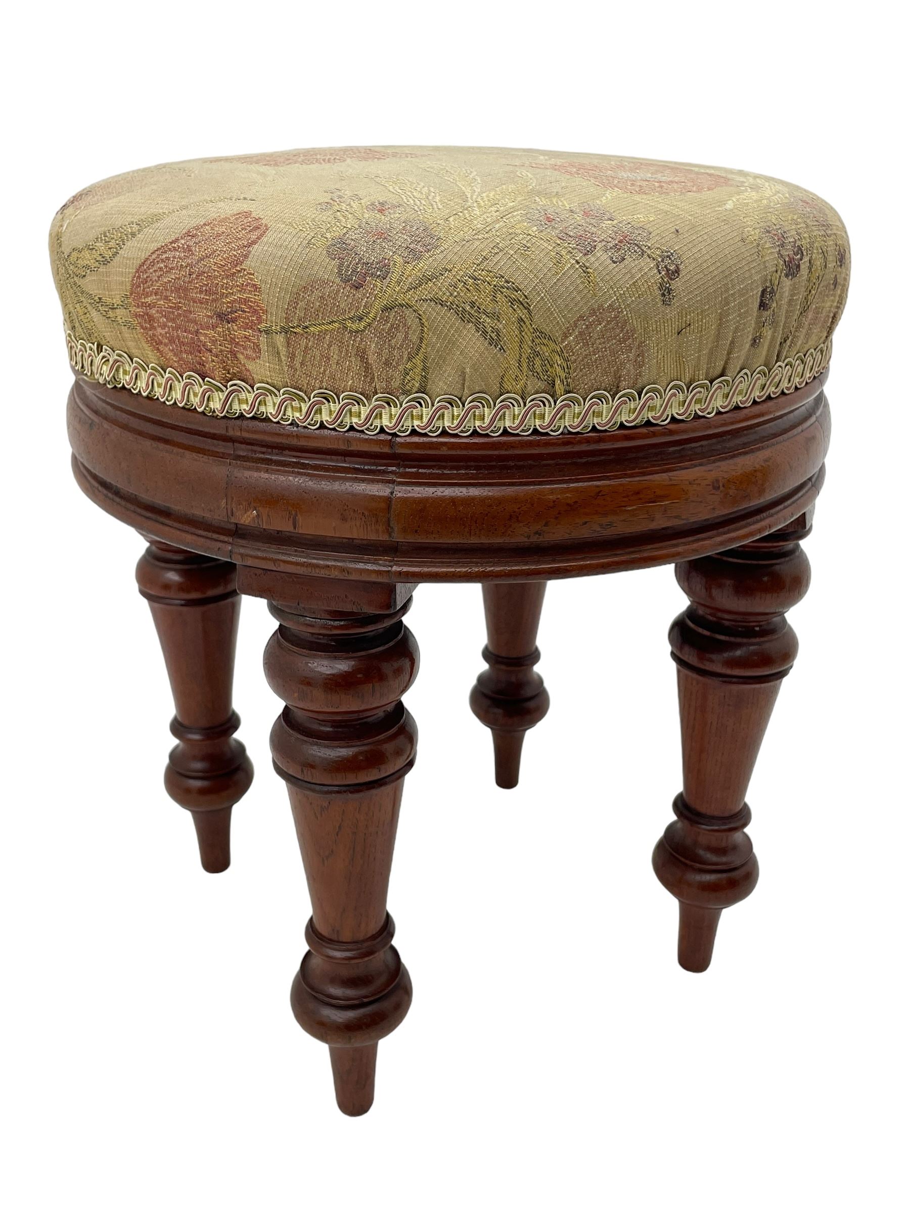 Pair of Victorian walnut circular stools, cushioned seats upholstered in floral pattern fabric, moulded seat rail over turned supports 