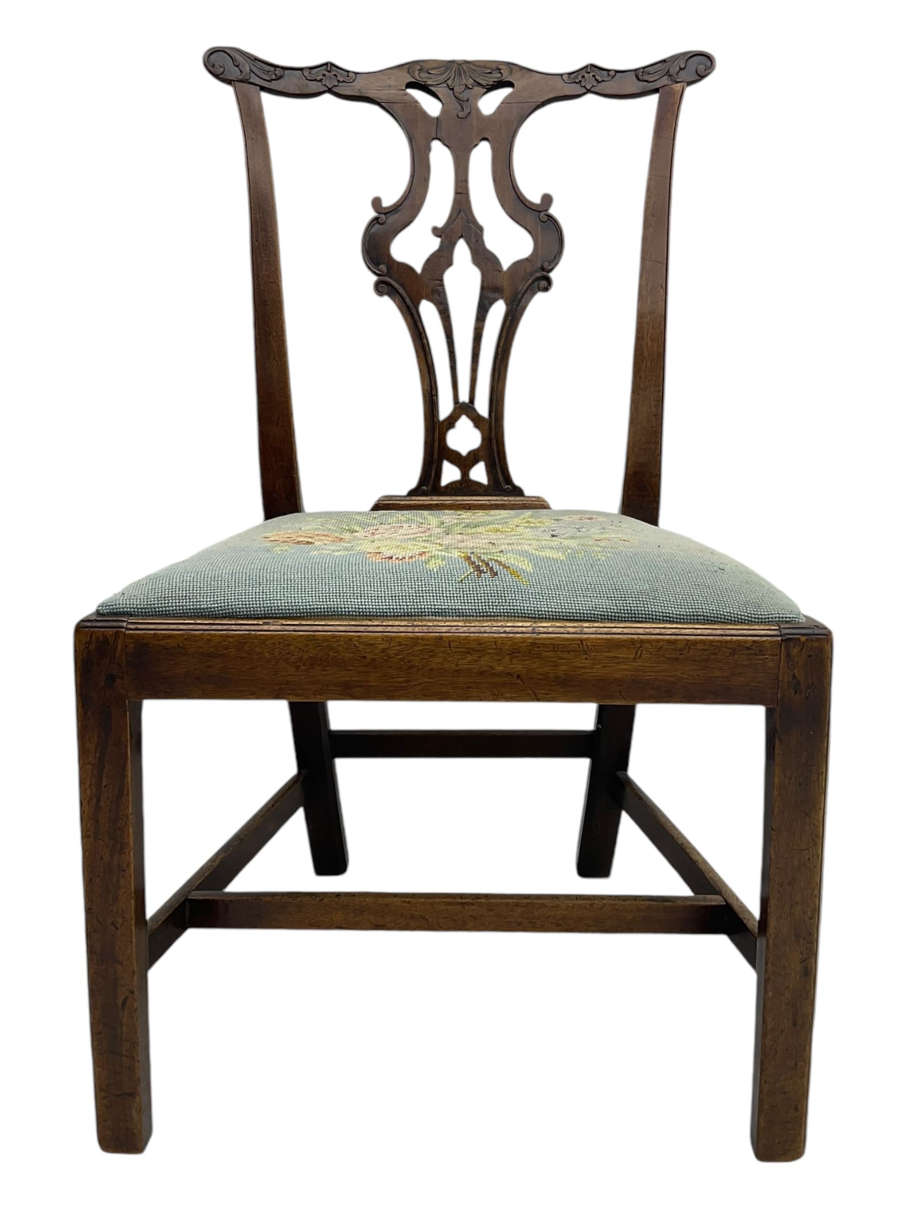 George III Chippendale design dining chair, shaped cresting rail carved with foliate scrolls over pierced and carved splat, floral needle-work upholstered drop-in seat, on square moulded supports united by H-stretchers 