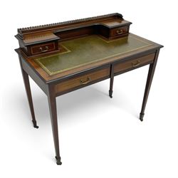 Edwardian inlaid mahogany writing desk, raised back with gilt metal gallery over two small drawers with satinwood banding, the rectangular moulded top with green leather inset writing surface, fitted with two drawers, on square tapering supports with spade feet, brass and ceramic castors 