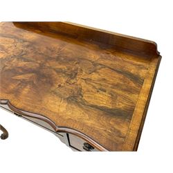 Mid-to-late 20th century figured walnut side table, raised back over figured top with cross banding and shaped front, fitted with three drawers, on cabriole supports with carved terminals 