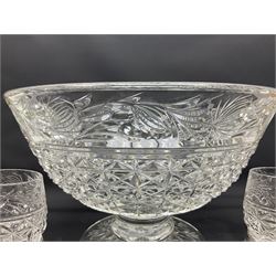 Large Stuart crystal pedestal punch bowl, of circular form, the rim with engraved floral decoration, upon spreading circular foot with radial cut decoration, with seven matching Stuart crystal drinking glasses, each with a C handle, each acid signed beneath, bowl H20cm