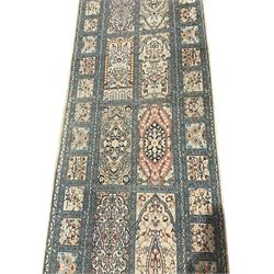 Fine Persian Kashmir ivory and pale indigo ground runner rug, the field decorated with sixteen rectangular panels depicting Mirab motifs and other traditional carpet designs, the border with repeating square panels of floral bouquets and foliate patterns