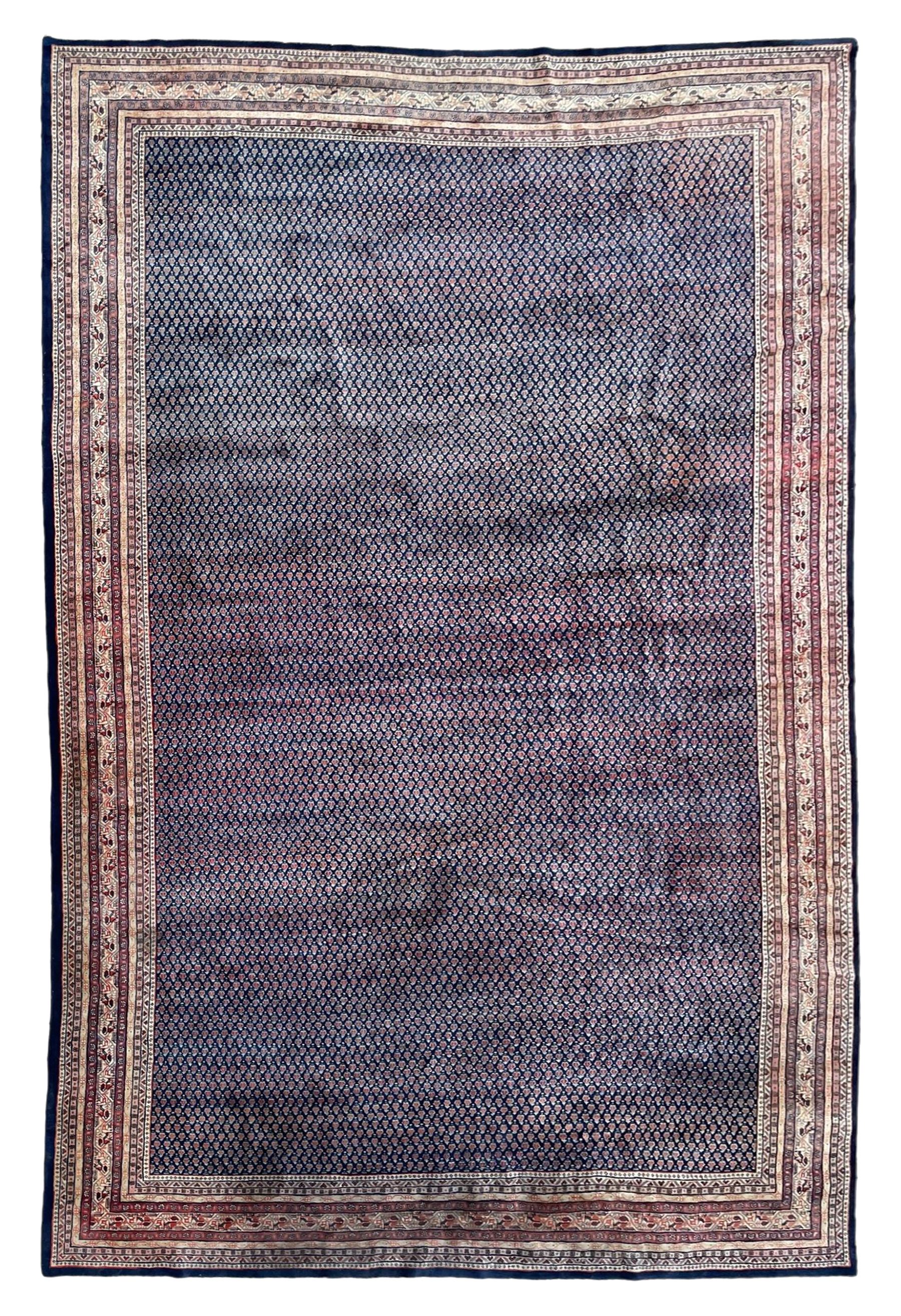 Large North-West Persian Arrak indigo ground carpet, the field decorated all-over with small Boteh motifs, multiple band border decorated with repeating geometric designs