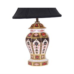 Pair of 20th century Royal Crown Derby 1128 Imari pattern table lamps, each of octagonal baluster form, with black fabric shades, each with printed mark beneath and date cods for 1996 and 1998, base H23cm, including shade H43cm