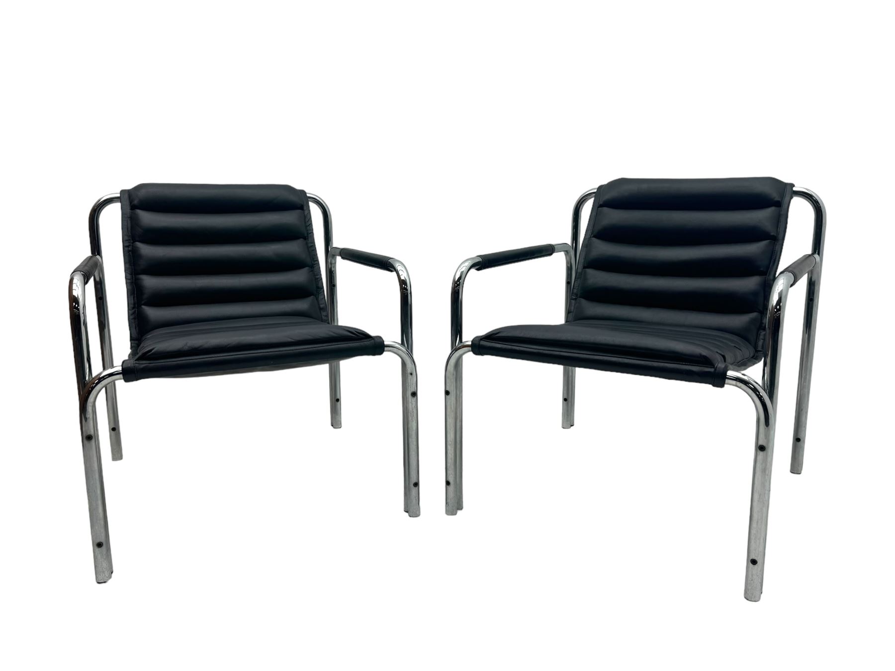 Baroumand Designs - pair of mid 20th century modernist armchairs, slung black leather seat with horizontal channel tufting, tubular chrome frame with curved arms, raised on tubular supports