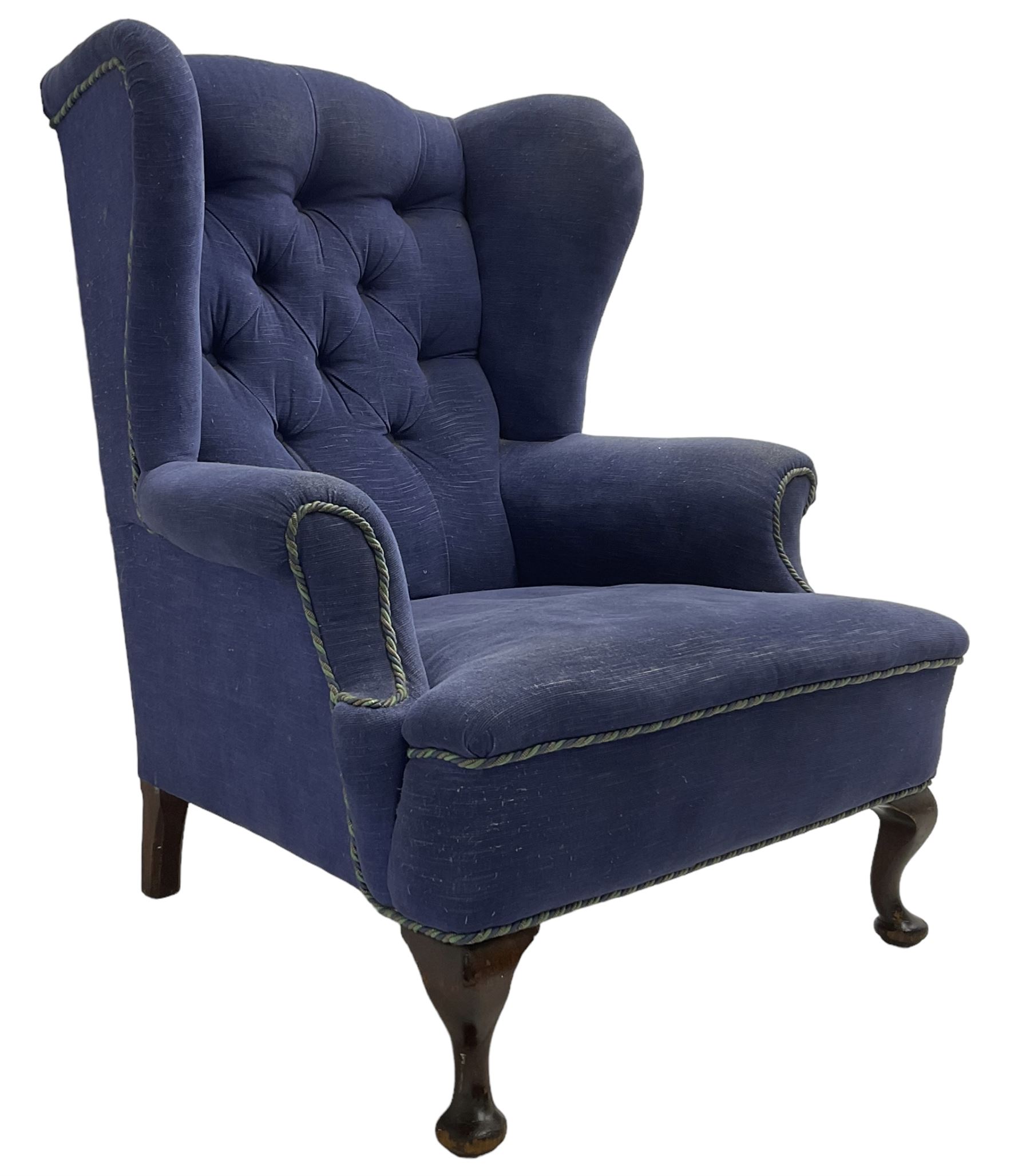 Early 20th century wingback armchair, upholstered in buttoned blue fabric, rolled and scrolled arms, on cabriole feet