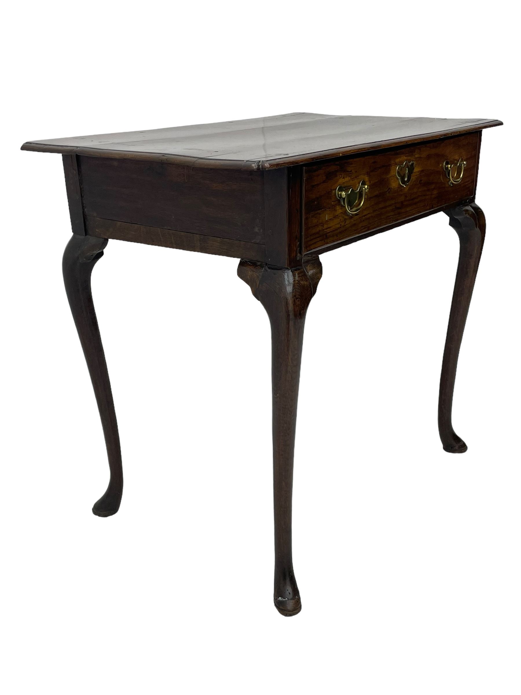 George III oak low-boy, moulded rectangular top with shaped corners, fitted with single drawer, shaped brass handle plates and escutcheon, on cabriole supports 