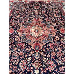 Persian Mahal indigo ground carpet, floral medallion on a field of swirling leafy branches and flower heads, shaped ivory field band decorated with flower head bouquets and trailing branches, the border decorated with floral motifs, within guard stripes