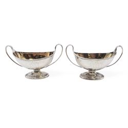 Pair of George III twin handled silver salts, of navette form with beaded rim and twin whiplash handles, each engraved to body with crest, upon stepped oval foot, London 1784, H8.5cm