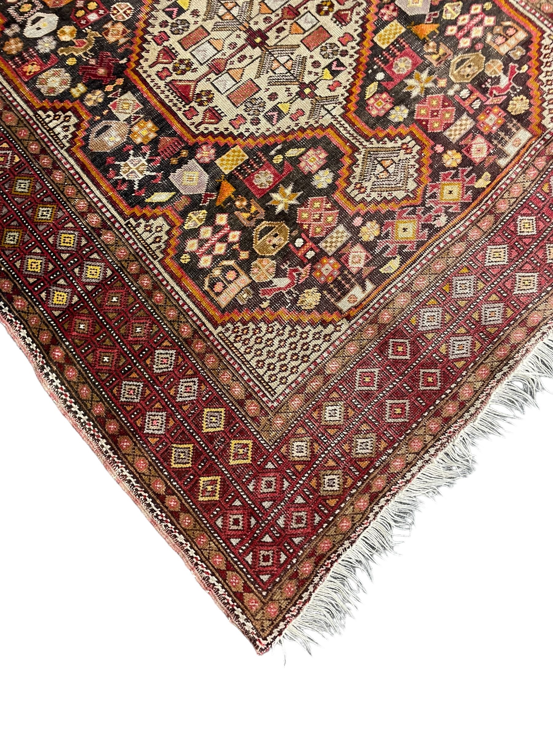 Persian Hamadan dark indigo ground rug, the field decorated with two connected pole medallions, decorated all over with small geometric and stylised bird motifs, geometric design border with repeating pattern 