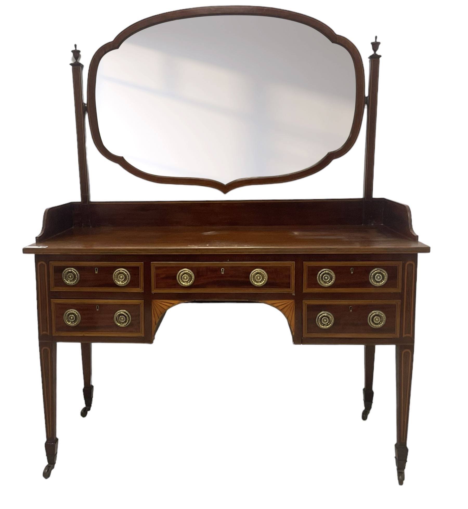 Edwardian inlaid mahogany kneehole dressing table, raised shaped oval bevelled mirror back, fitted with five drawers with banding and stringing, on square tapering supports with castors