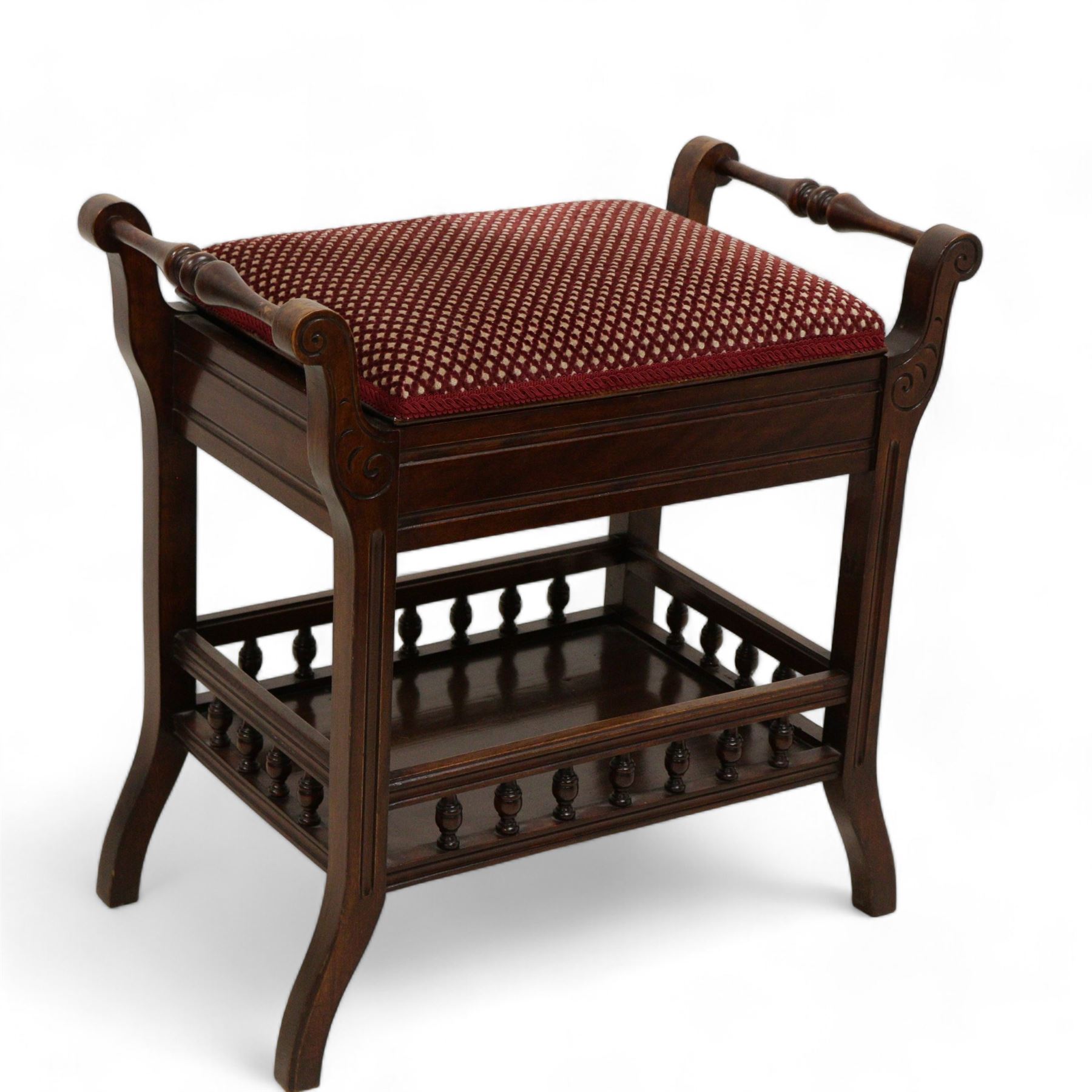 Late Victorian walnut piano stool, hinged upholstered seat enclosing storage space flanked by turnings, on S-scroll carved supports terminating to splayed feet, united by galleried undertier 