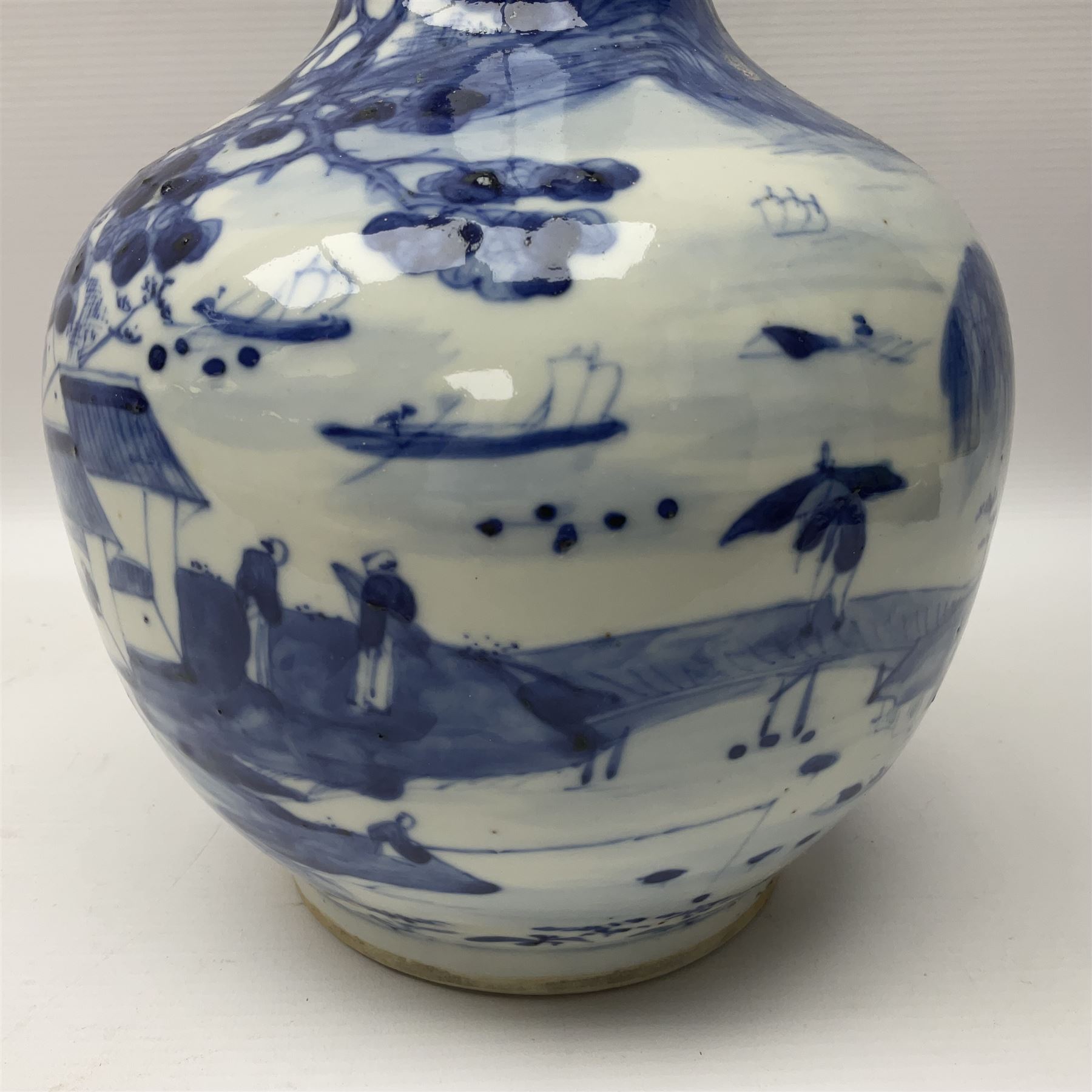 Late 18th/early 19th century Chinese blue and white bottle vase, decorated with a landscape scene containing dwellings, prunus and pine trees, boats and bridges, and populated with figures, with character mark beneath, H35cm