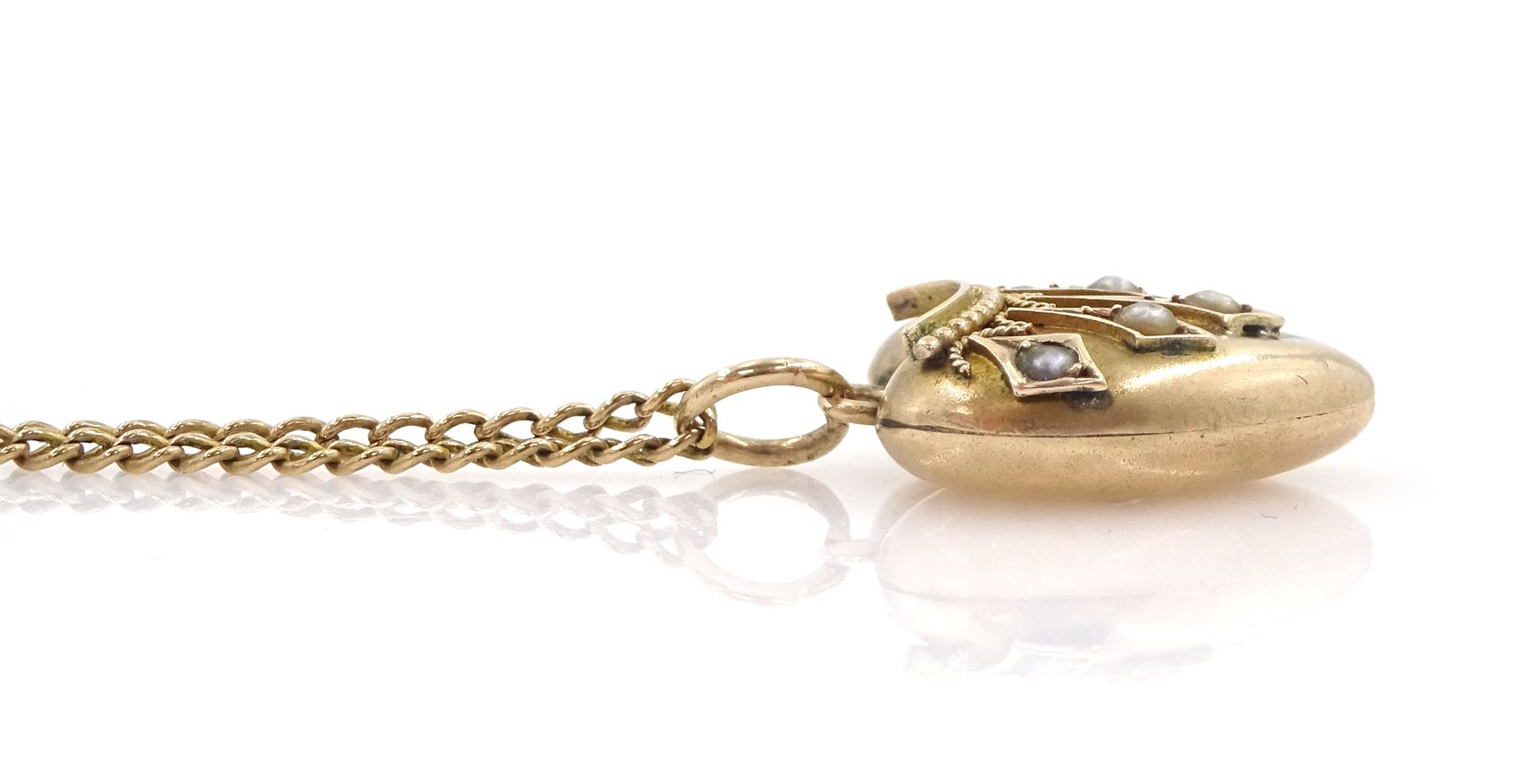 Early 20th century 9ct gold seed pearl and applied wirework heart pendant, on 10ct gold chain necklace