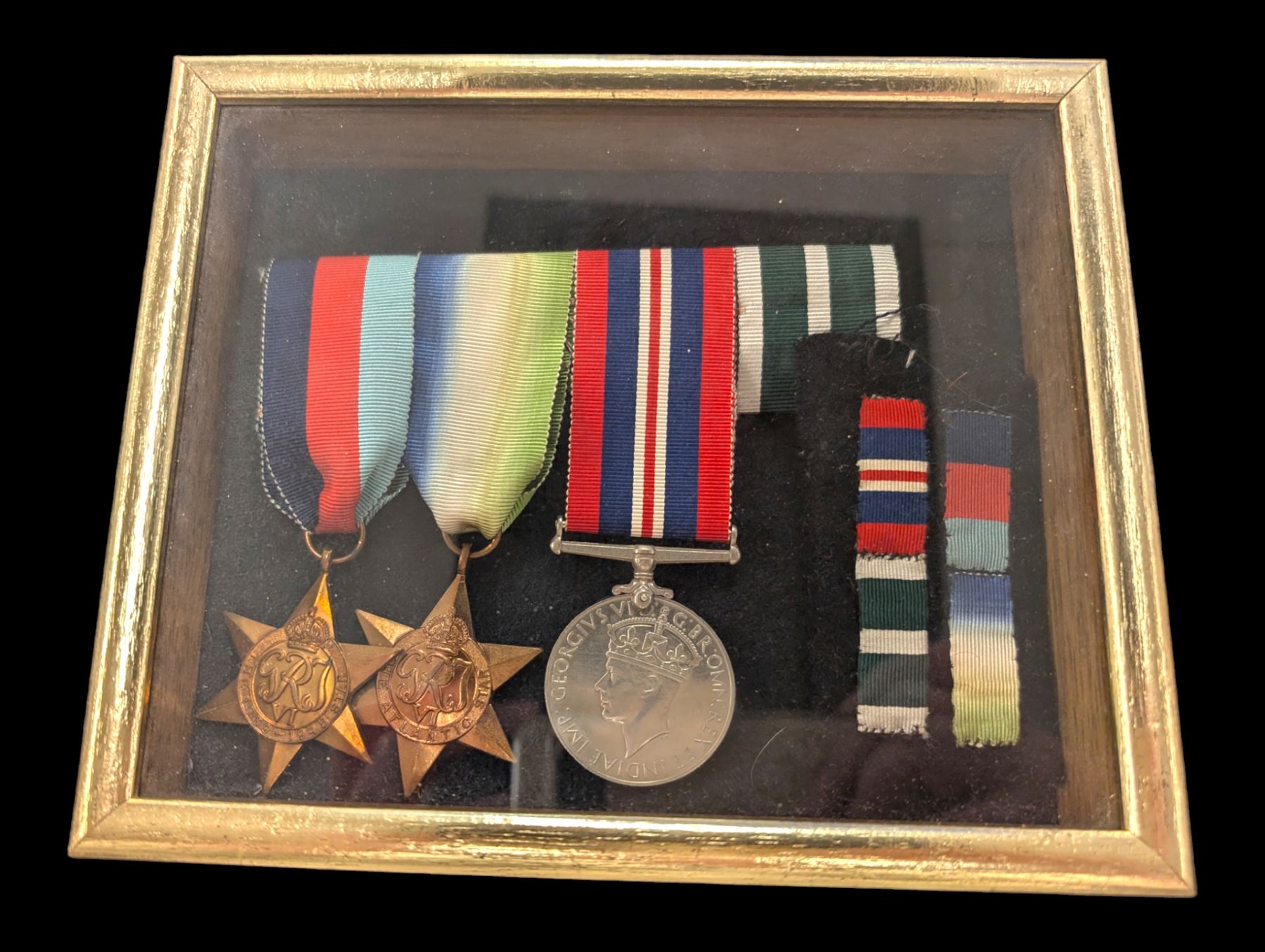 World War II medal group, including Atlantic Star and General Service medal, inscribed Thomas Crawford in glazed display frame