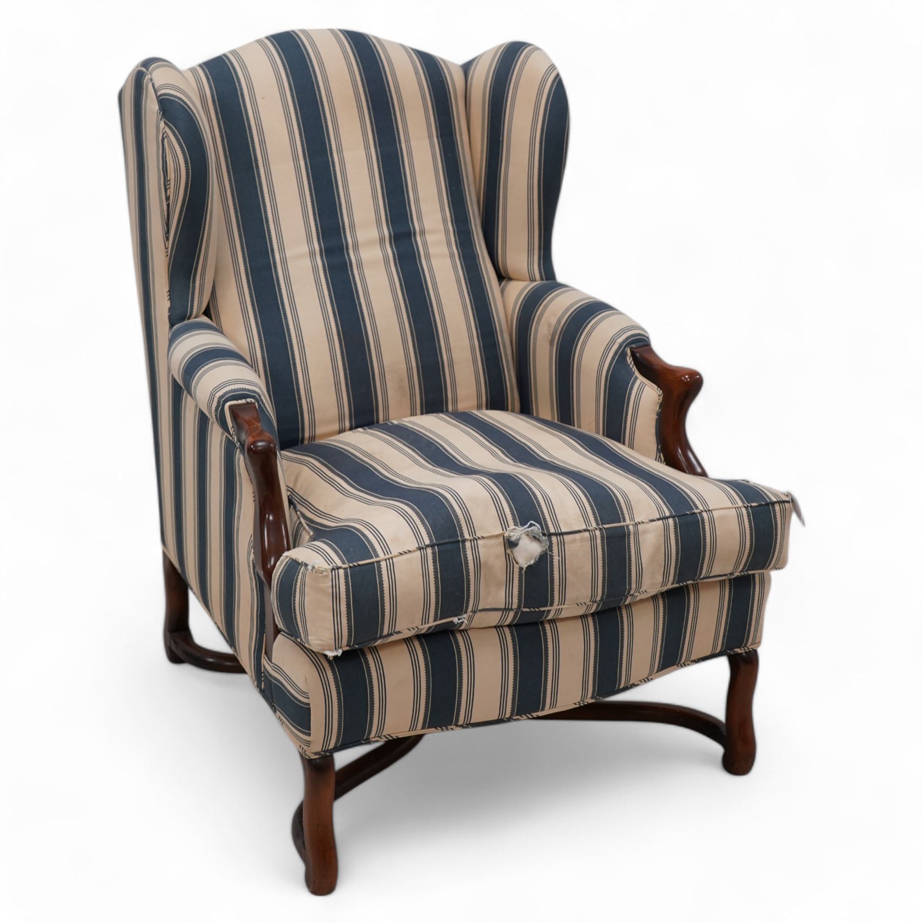 Georgian design wingback armchair, upholstered in blue and cream striped fabric, on shaped supports united by serpentine x-framed stretchers 