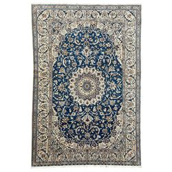 Persian Kashan blue ground rug, central floral rosette medallion within a field of swirlin...