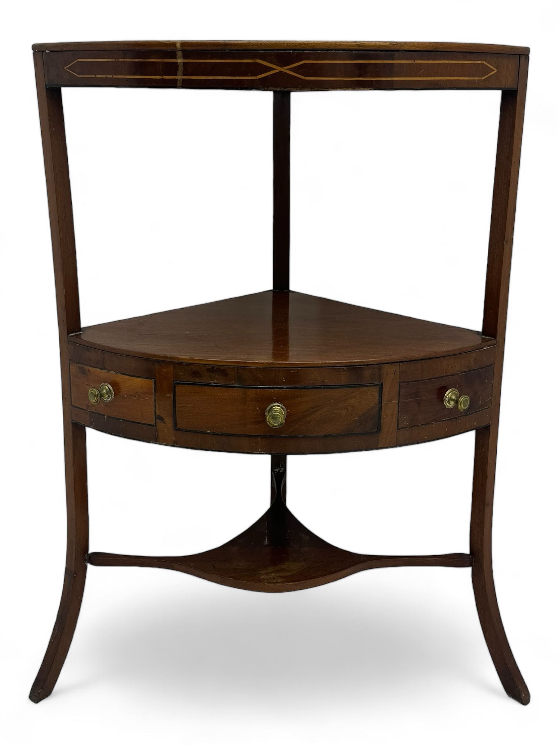 George III mahogany two-tier corner washstand, the inlaid top with geometric border, central drawer flanked by two faux drawers each with brass pull handle, on splayed supports united by shaped under-tier