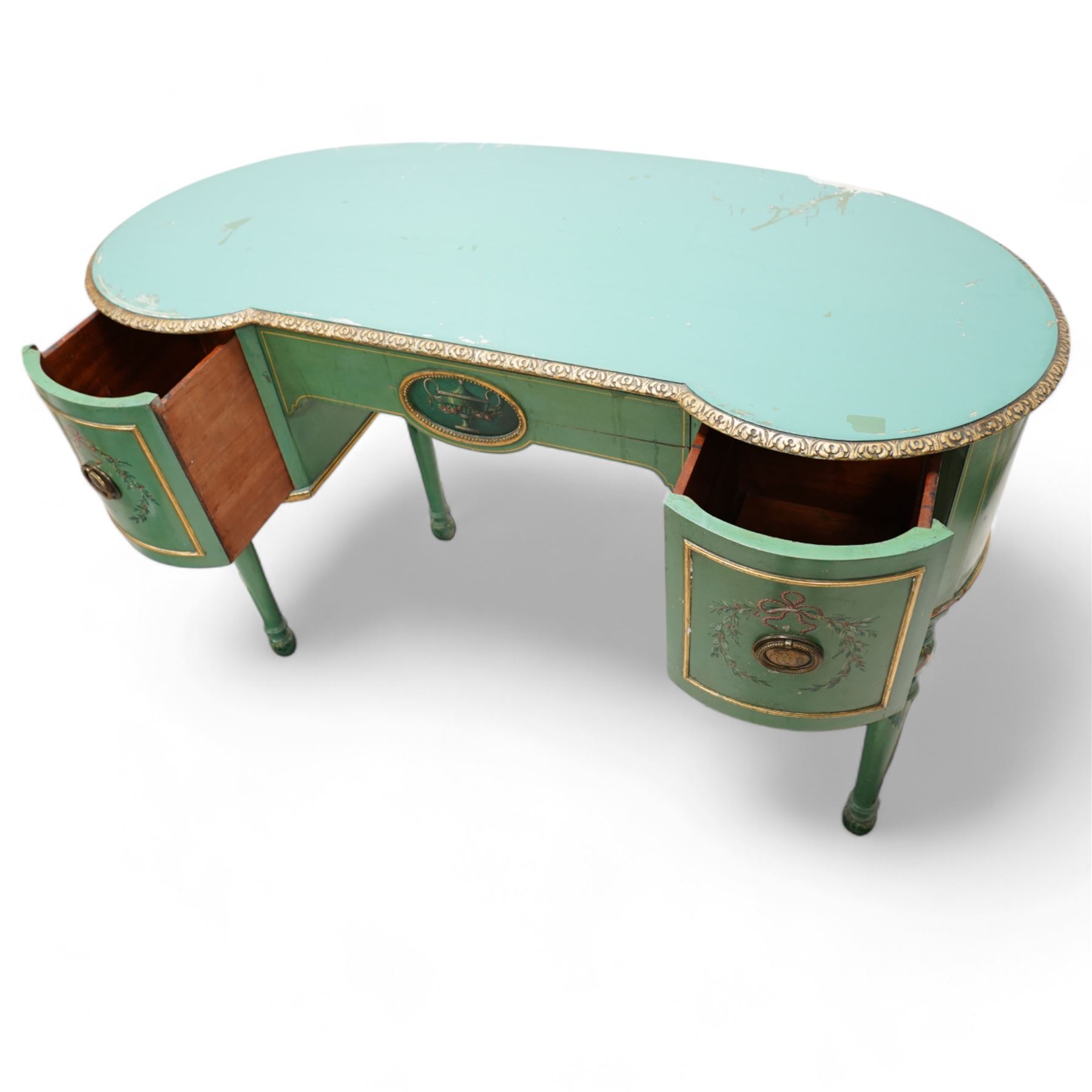 Edwardian Adam Revival green-painted and parcel gilt kneehole desk or dressing table, kidney shaped form with foliate carved edge, fitted with three drawers painted with urn and fruiting laurel wreaths with ribbon ties, on acanthus leaf and draped festoon decorated turned supports 