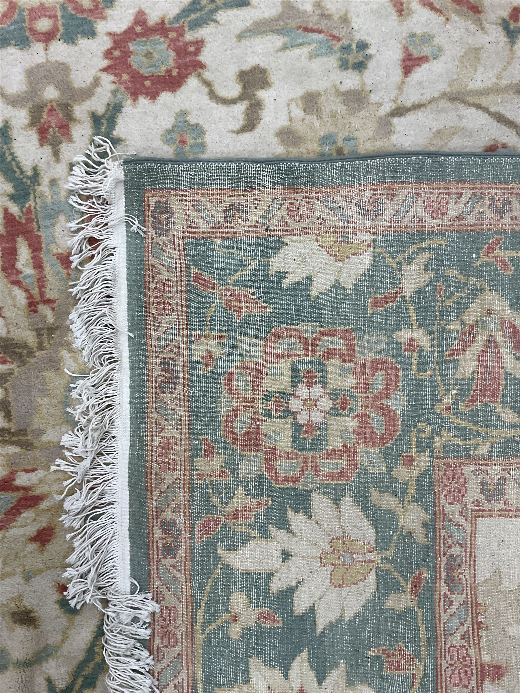 Persian Ziegler design carpet, pale ground field decorated with large stylised plant motifs, the border decorated with large floral motifs within repeating guards