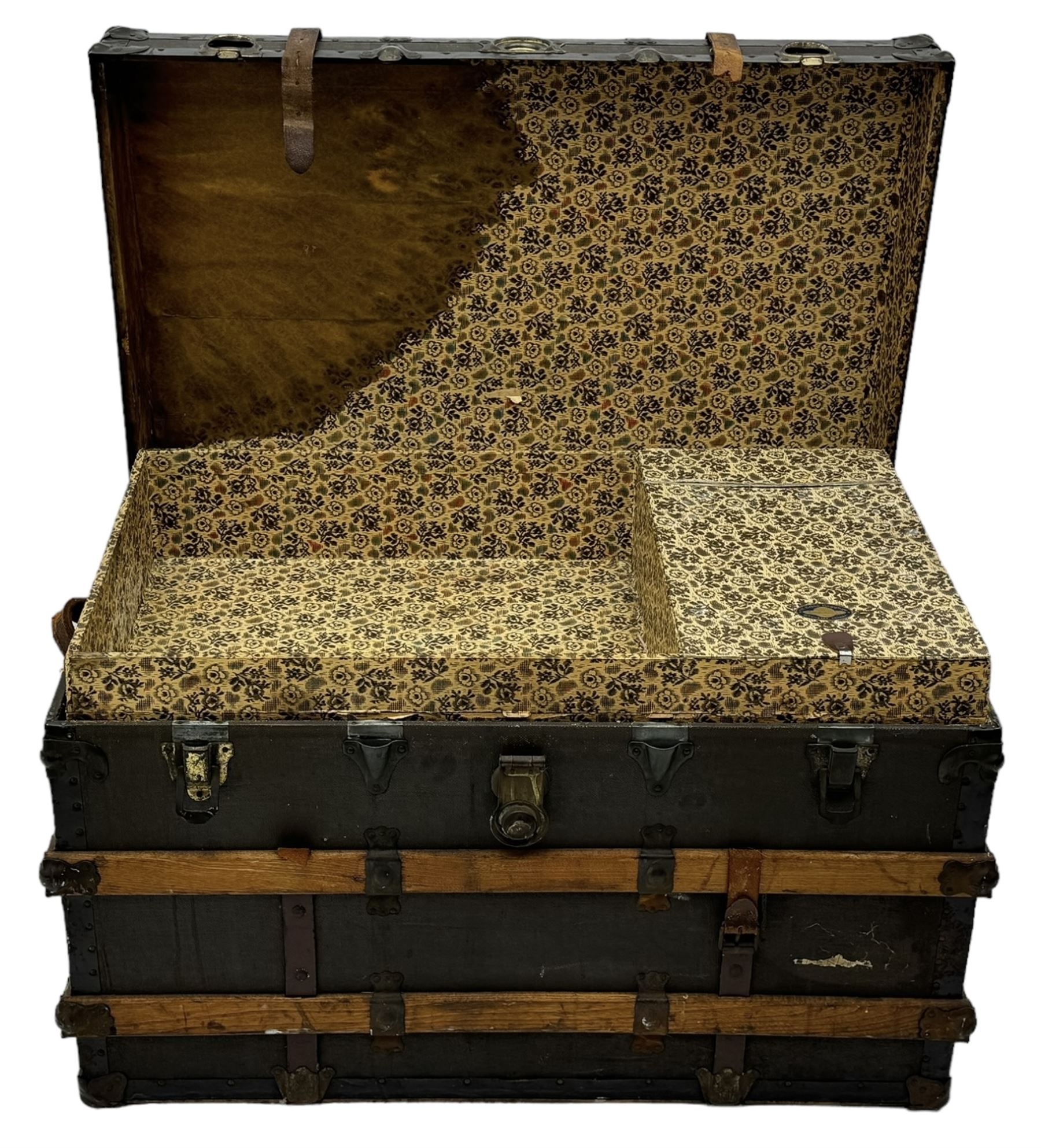 Early 20th century 'McBrine Baggage' steamer trunk, oak frame and black canvas covering, featuring metal hardware and leather straps, fitted with central lock, additional latches, and corner protectors, the interior is lined with floral-patterned paper and includes a removable top tray with makers label 