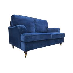 Howard design - two-seat sofa upholstered in blue fabric, traditional shape with rolled arms, on walnut finish turned feet with brushed metal cups and castors