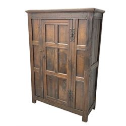 17th century and later oak hall cupboard, panelled front and sides with moulded frame, enclosed by single door with wrought metal hinges and handle, the interior fitted with hooks, on stile supports 