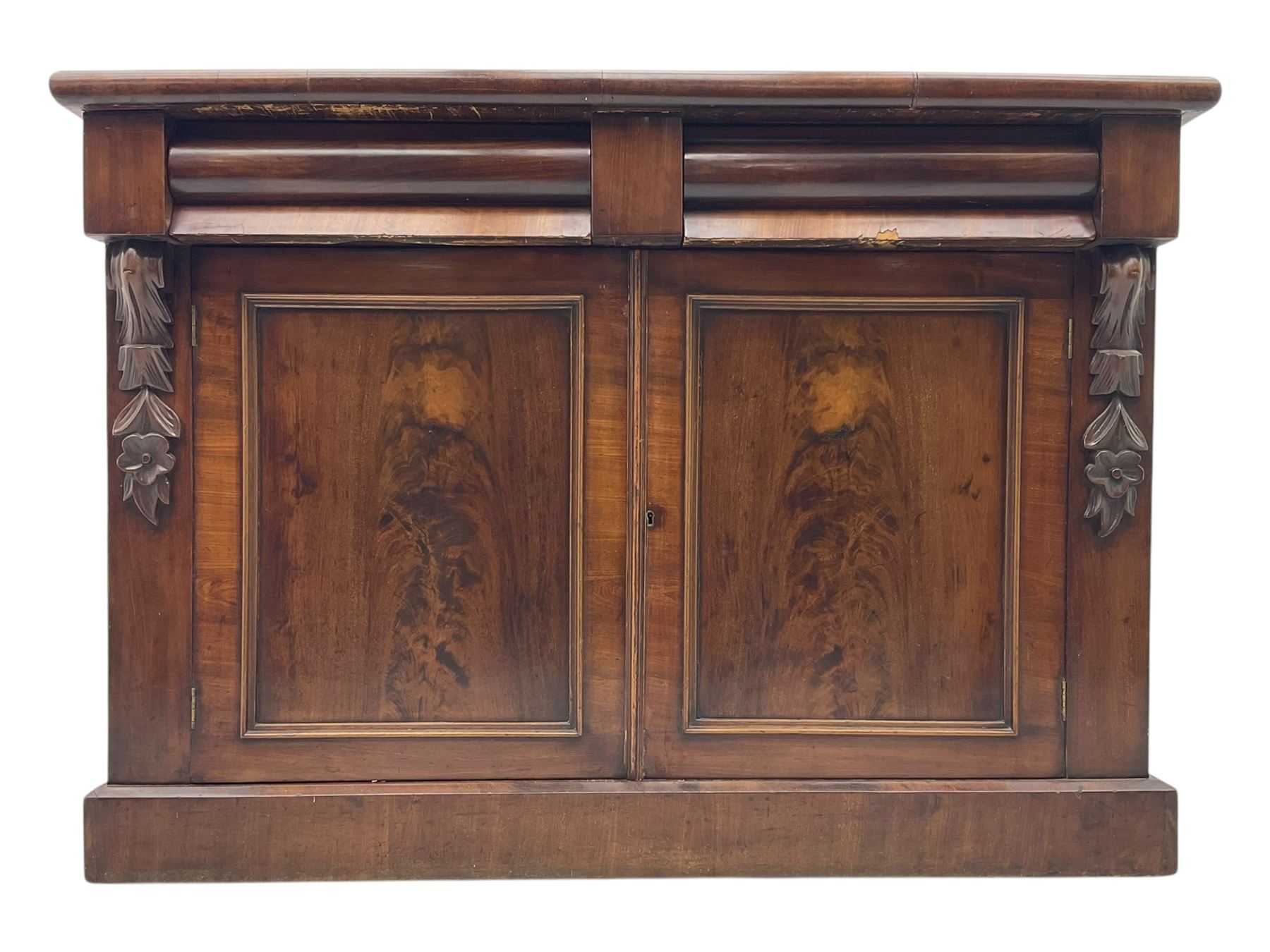 Mid 19th century mahogany sideboard, rectangular top over two frieze drawers with rounded edges, flanked by floral carved corbels, over two panelled cupboard doors, raised on a plinth base