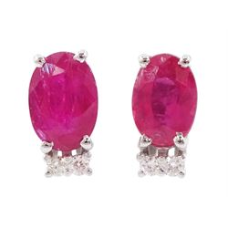 Pair of 18ct white gold oval cut ruby and two stone round brilliant cut diamond stud earrings, total ruby weight approx 1.10 carat